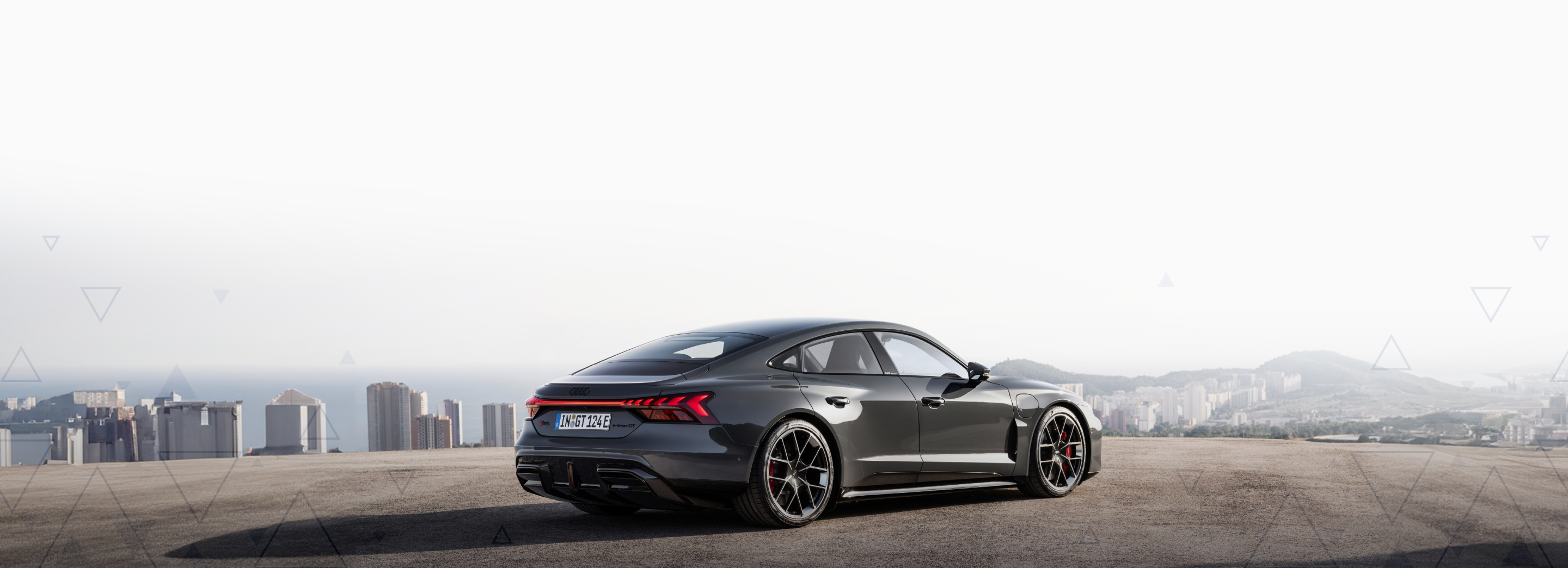 Black luxury car in a wide space heading towards the light